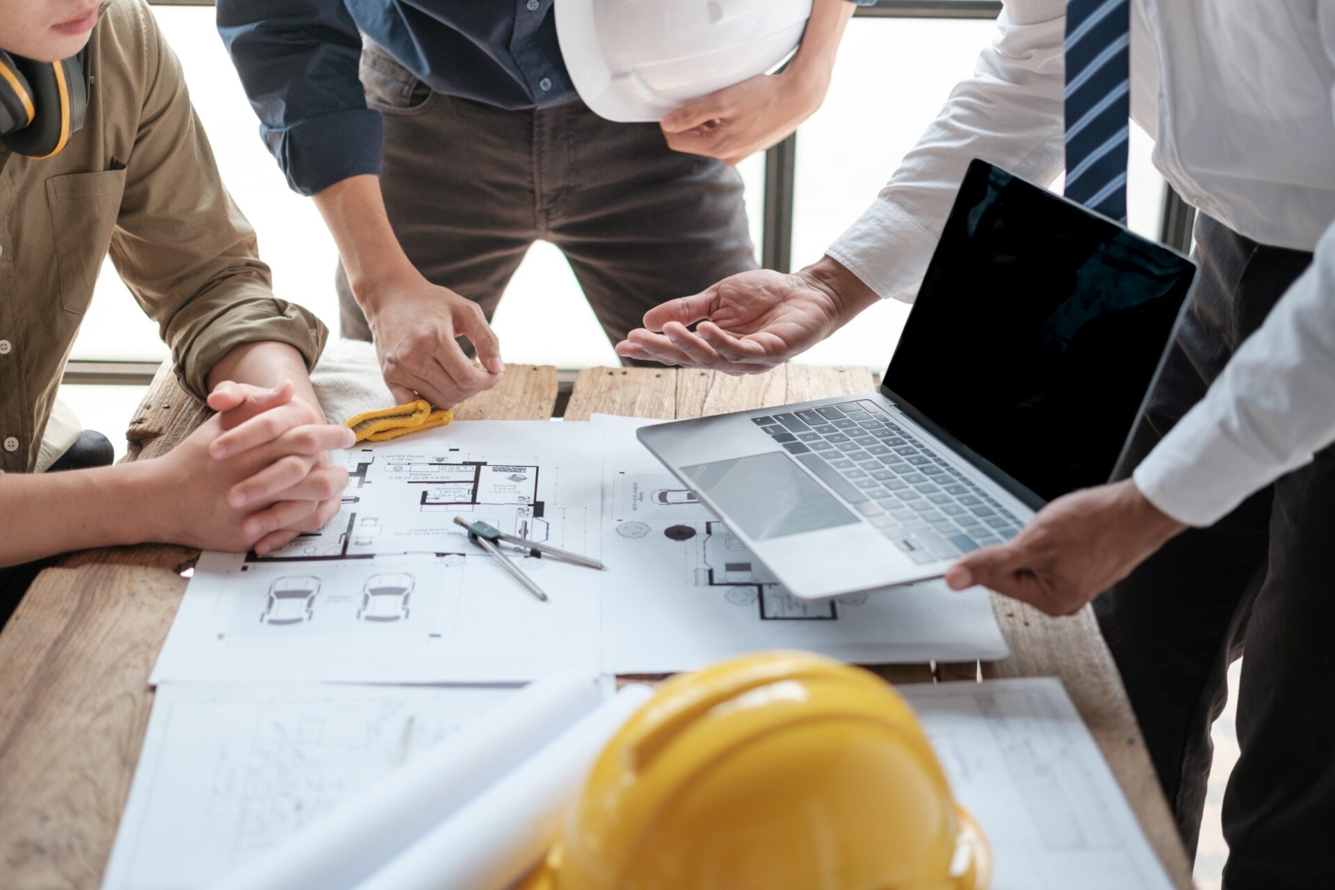 team construction consultation on a computer and yellow hard hat